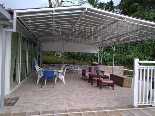 戈亚夫Villa de 3 chambres avec piscine privee jardin clos et wifi a Goyave a 6 km de la plage的一个带桌椅的伞下庭院