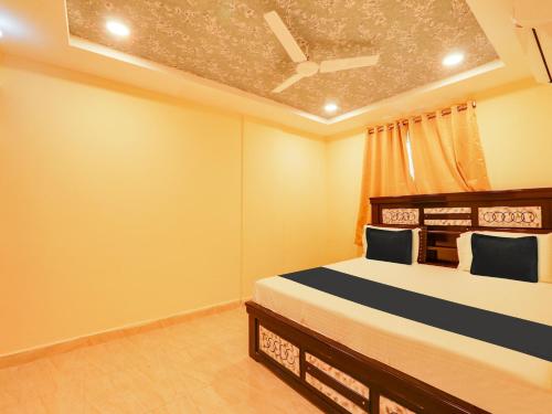 瓦朗加尔Super OYO Flagship Hotel Bommarillu的一间卧室设有一张床和天花板
