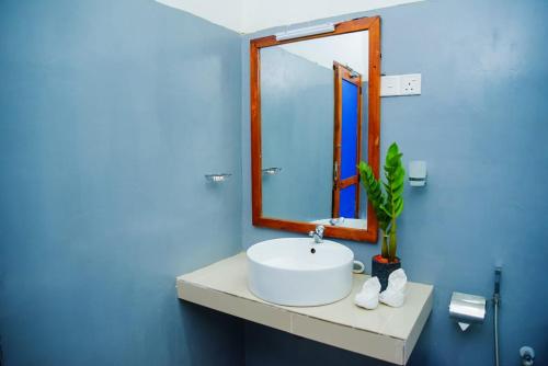 达瓦拉维Lily Resort Udawalawe的浴室设有白色水槽和镜子