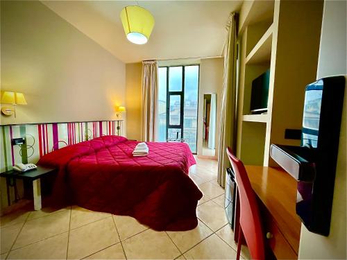蒙塔尔图富戈Le Ceramiche - Hotel Residence ed Eventi的一间卧室配有红色的床和电视