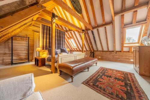 Belchamp OttenHuge luxury loft cottage in historic country estate - Belchamp Hall Hayloft的一间设有床、沙发和地毯的房间