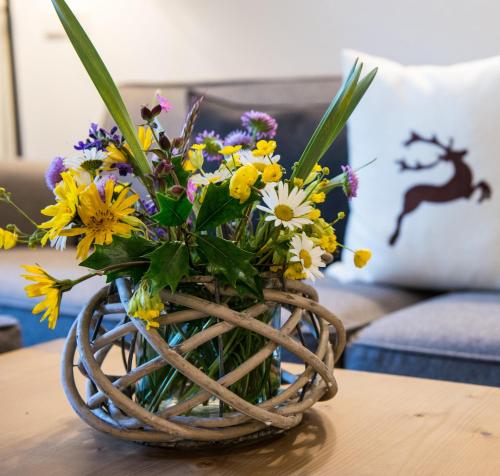 圣坎迪朵锡赛福特住宅酒店的桌上一篮子里的一束鲜花