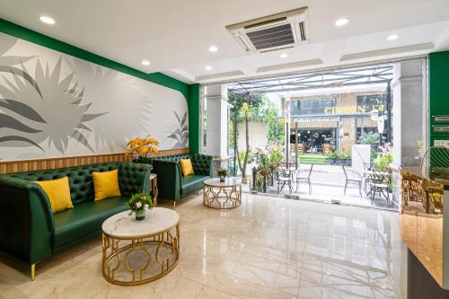 胡志明市El Ocaso Boutique Hotel的大堂设有绿色的沙发和桌子