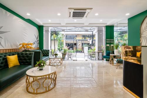 胡志明市El Ocaso Boutique Hotel的大堂设有绿色沙发和桌子