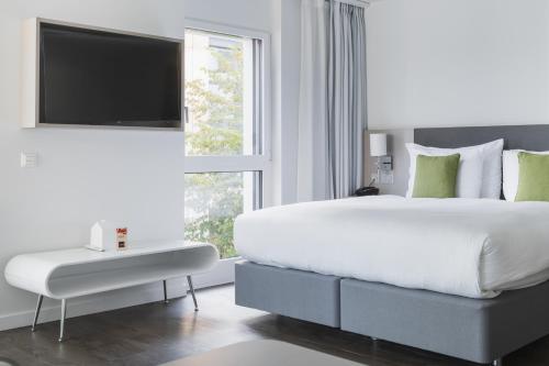 尼翁尼翁百思公寓式酒店的白色的卧室设有一张大床和一个窗户