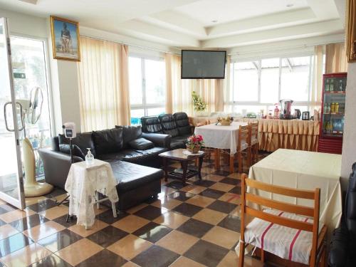 碧差汶Phetsuwan Hotel的客厅配有沙发和桌子
