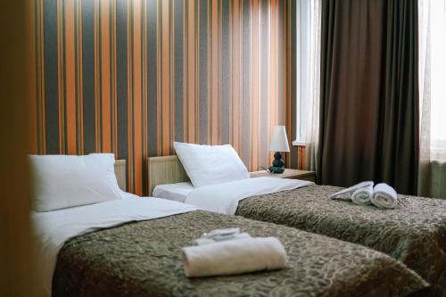 第比利斯达奇酒店的两张位于酒店客房的床,配有毛巾