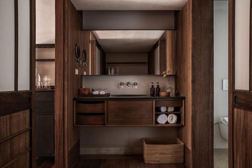 杭州杭州西湖安隅酒店的一个带木制橱柜和水槽的厨房