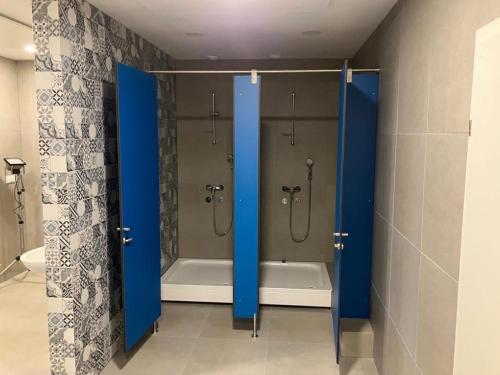 马里博尔CafDorm的带淋浴和蓝色门浴缸的浴室