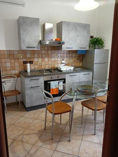 博洛尼亚Home Sweet Home的厨房配有玻璃桌和椅子