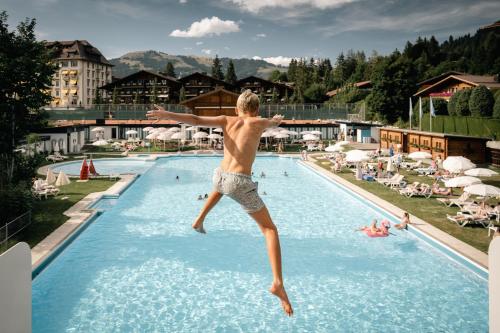 格施塔德格施塔德宫殿酒店的跳进游泳池的年轻人