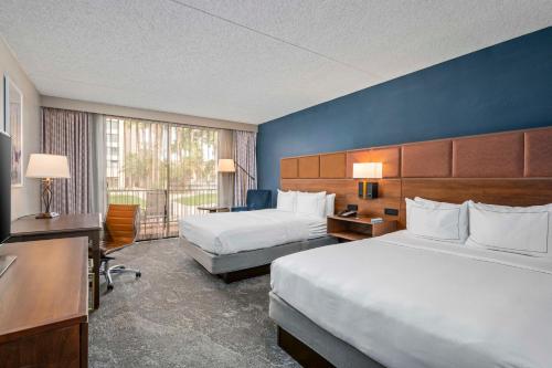 土桑图森希尔顿逸林酒店 - 里德公园的酒店客房设有两张床和大窗户。