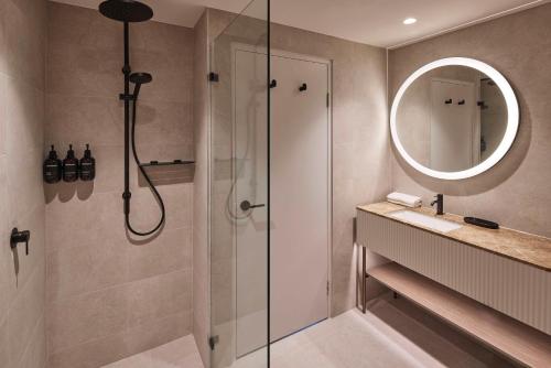 悉尼The Miller Hotel North Sydney的带淋浴、盥洗盆和镜子的浴室