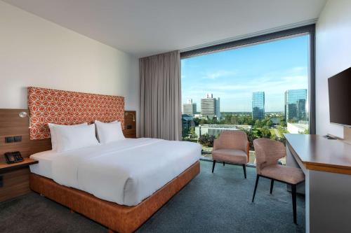 美因河畔法兰克福DoubleTree by Hilton Frankfurt Niederrad的酒店客房设有一张床和一个大窗户