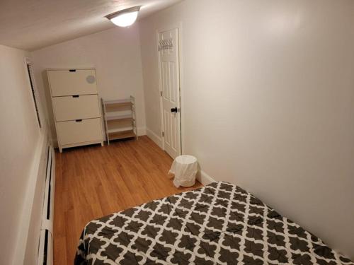 波士顿GUEST HOUSE NEAR DOWTOWN BOSTON的一间卧室配有一张带黑白毯子的床