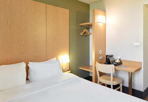 塞纳河畔伊夫里B&B HOTEL Paris Italie Porte de Choisy的配有一张床和一张书桌的酒店客房