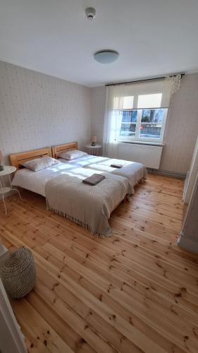 KadrinaKadrina St. Catharine's Guesthouse的一间卧室设有一张大床,铺有木地板