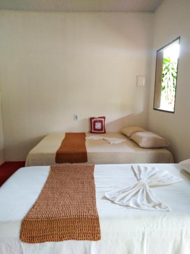 库穆鲁沙蒂巴Chalé Ilha Verde-Cumuruxatiba的配有2张床铺的小房间,配有白色的床