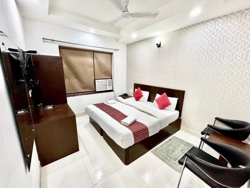新德里Hotel Siam International的一间卧室配有红色枕头的床