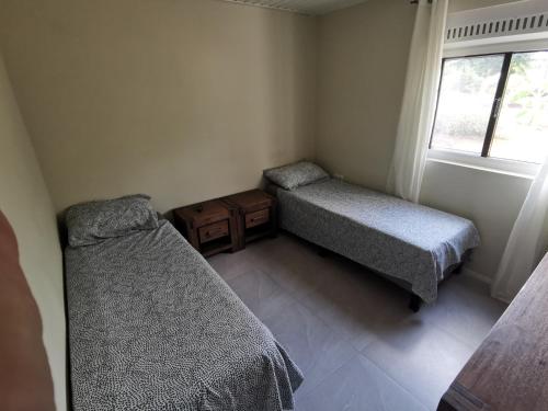 威廉斯塔德Guesthouse Fuik的一间小卧室,配有两张床和窗户