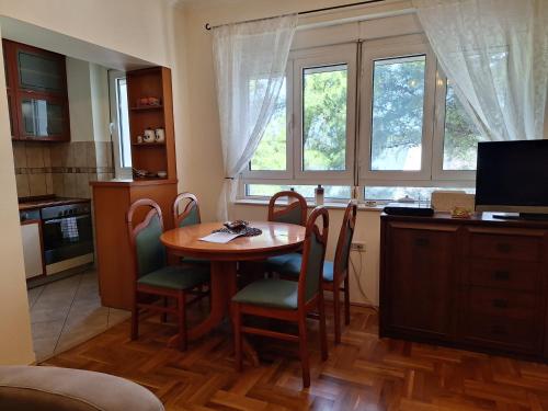 波德戈里察Apartment Music-center, in the center of Podgorica的厨房配有桌椅和窗户。