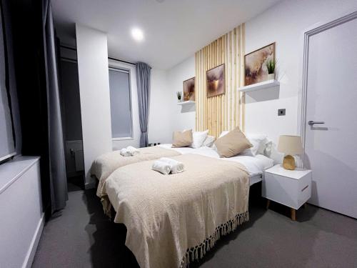 布拉克内尔Impeccable 2-Bed Luxury Apartment in Berkshire的一间卧室配有两张床,床上配有毛巾
