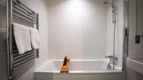 布拉克内尔Impeccable 2-Bed Luxury Apartment in Berkshire的白色的浴室设有浴缸和淋浴。