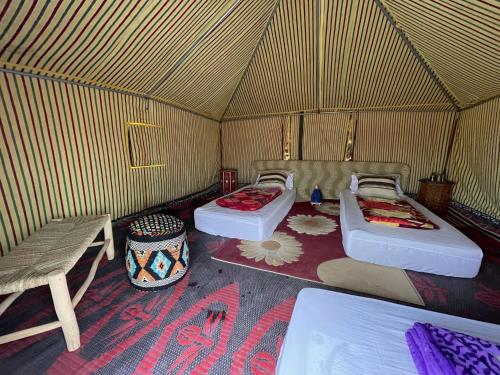 达赫拉Secret Spot Dakhla的圆顶帐篷内带两张床和一张长凳的房间