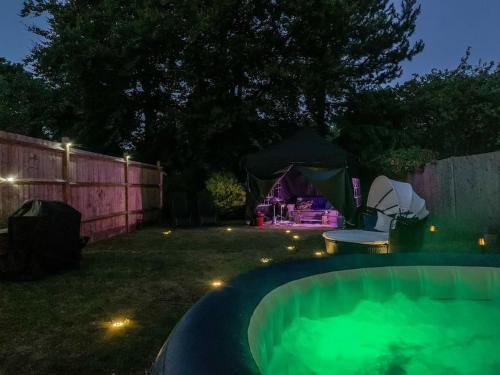 奥平顿1 Bedroom home with hot tub & private garden的后院在晚上设有热水浴池和帐篷