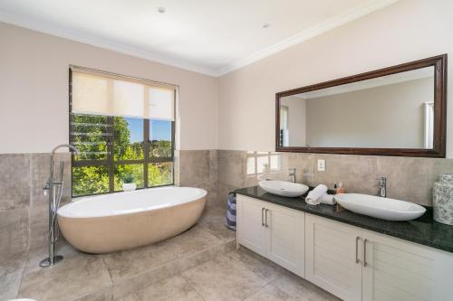 克尼斯纳Super Beachfront views- Executive Villa - 6 bedrooms的一间带两个盥洗盆和大镜子的浴室