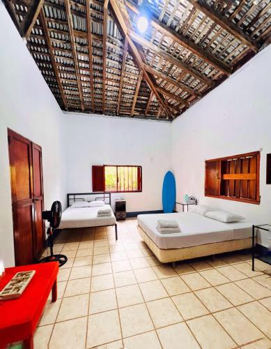 波内洛亚Cacerola Beach House的一间设有两张床和一张红色桌子的房间