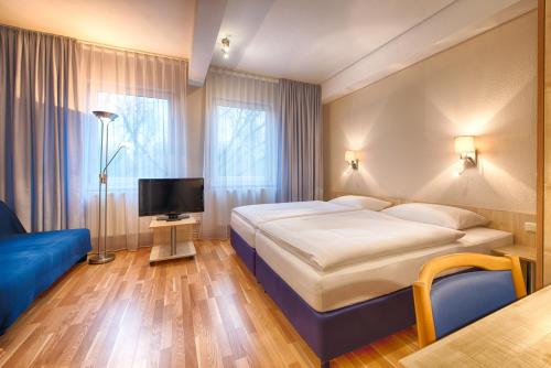 柏林柏林市美森怡居酒店的酒店客房,配有床和电视