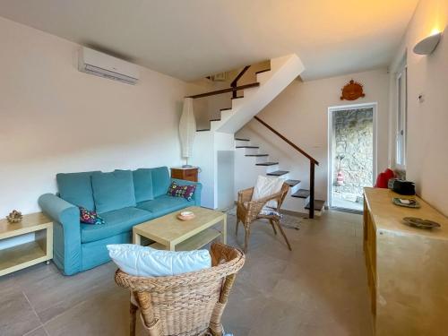 Isola del GiglioCasa Caretta con terrazza panoramica的客厅配有蓝色的沙发和桌子