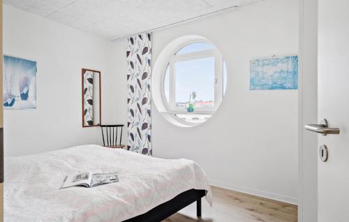 灵克宾Amazing Apartment In Ringkbing With Wifi的一间卧室设有一张床和一个圆形的窗户。