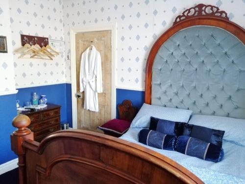 特拉莫尔Glenart House的一间卧室配有一张大床和木制床头板