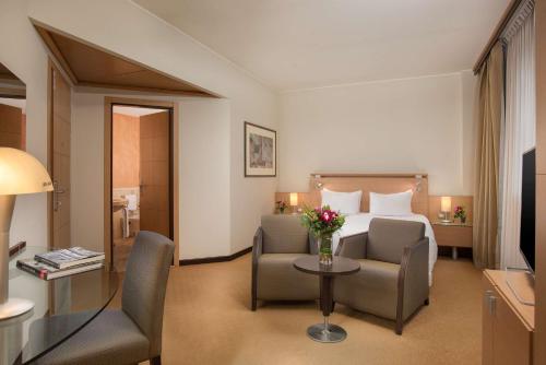 维拉诺瓦博洛尼亚维拉诺瓦NH酒店的酒店客房带一张床、一张桌子和椅子