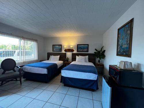新士麦那海滩夜曲汽车旅馆的酒店客房设有两张床和电视。