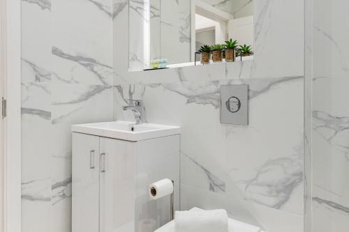 伦敦Welcoming and Spacious Apartment- Excellent Location的白色的浴室设有水槽和淋浴。