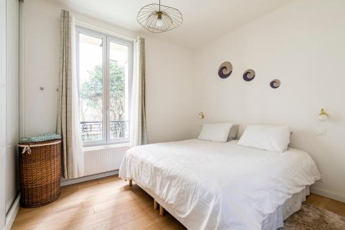 皮托Appartement Puteaux la Defense的白色的卧室设有床和窗户