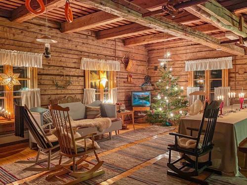 HyrynsalmiHoliday Home Laattajan hirsipirtti by Interhome的小木屋内的客厅,配有圣诞树