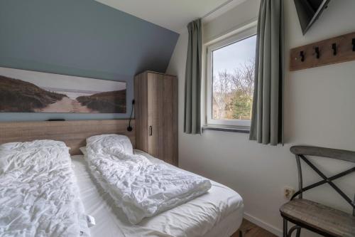 德瓦尔Nieuwlanderweg 77的一间卧室设有一张床和一个窗口