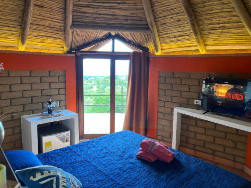 莱瓦镇MALOKAS AGUA VIDA & NATURALEZA的一间卧室设有一张床、一台电视和一个窗口。