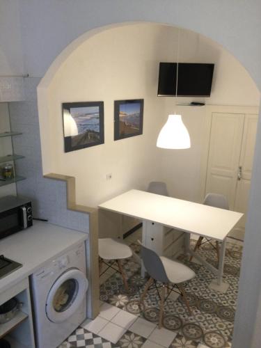 维耶斯泰Medieval terraced house in Vieste Vecchia的厨房配有桌子和洗衣机。