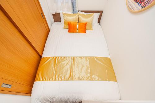 东京KYARA HOTEL　亀戸501的一张带橙色枕头的床