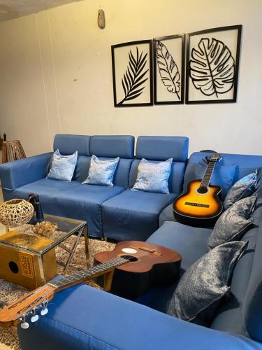 皮乌拉Casa Johans的客厅配有蓝色沙发和吉他