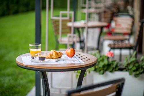 鲁塞Arletti Hotel的一张桌子,上面放着苹果和一杯橙汁