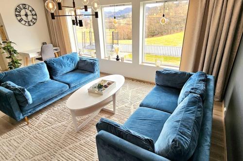 灵达尔Familie bolig med hage的客厅配有蓝色的沙发和桌子
