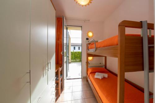 巴韦诺Camping Residence & Lodge Orchidea的小型客房设有双层床和阳台。