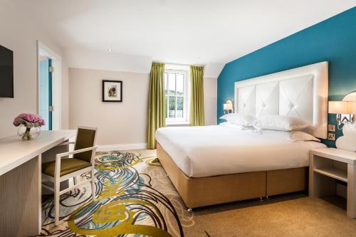 格拉斯米尔水仙花酒店及水疗中心的酒店客房设有一张大床和一张书桌。