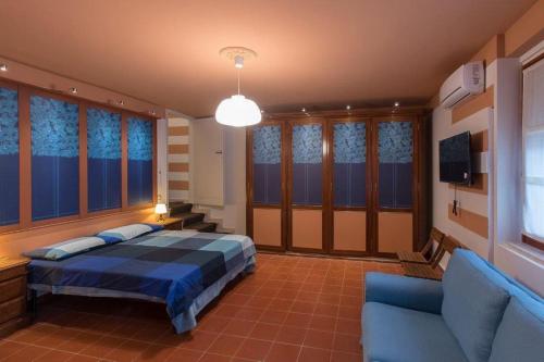 蒙特卡蒂尼泰尔梅Montecatini Terme Art Loft的一间卧室配有一张床、一张沙发和一台电视。